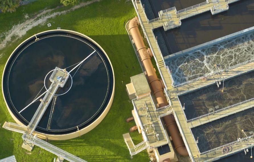 Aerial view of modern water cleaning facility at urban wastewater treatment plant. Purification process of removing undesirable chemicals, suspended solids and gases from contaminated liquid.